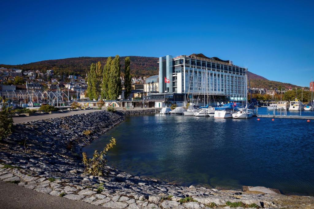 a marina with boats in the water and a building at Best Western Premier Hotel Beaulac in Neuchâtel