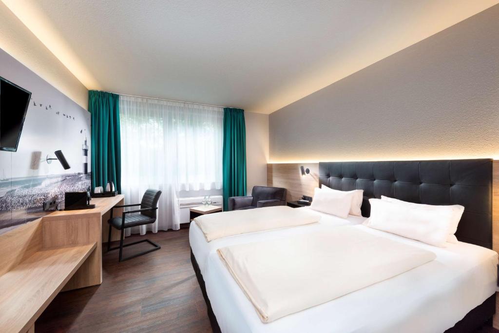 a hotel room with a large bed and a television at Best Western Hotel Achim Bremen in Bremen