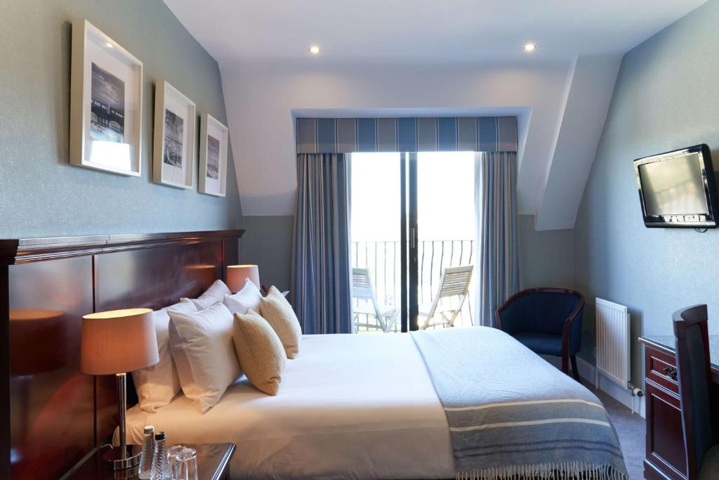 a hotel room with a bed, chair, and nightstand at Best Western Plus The Connaught Hotel and Spa in Bournemouth
