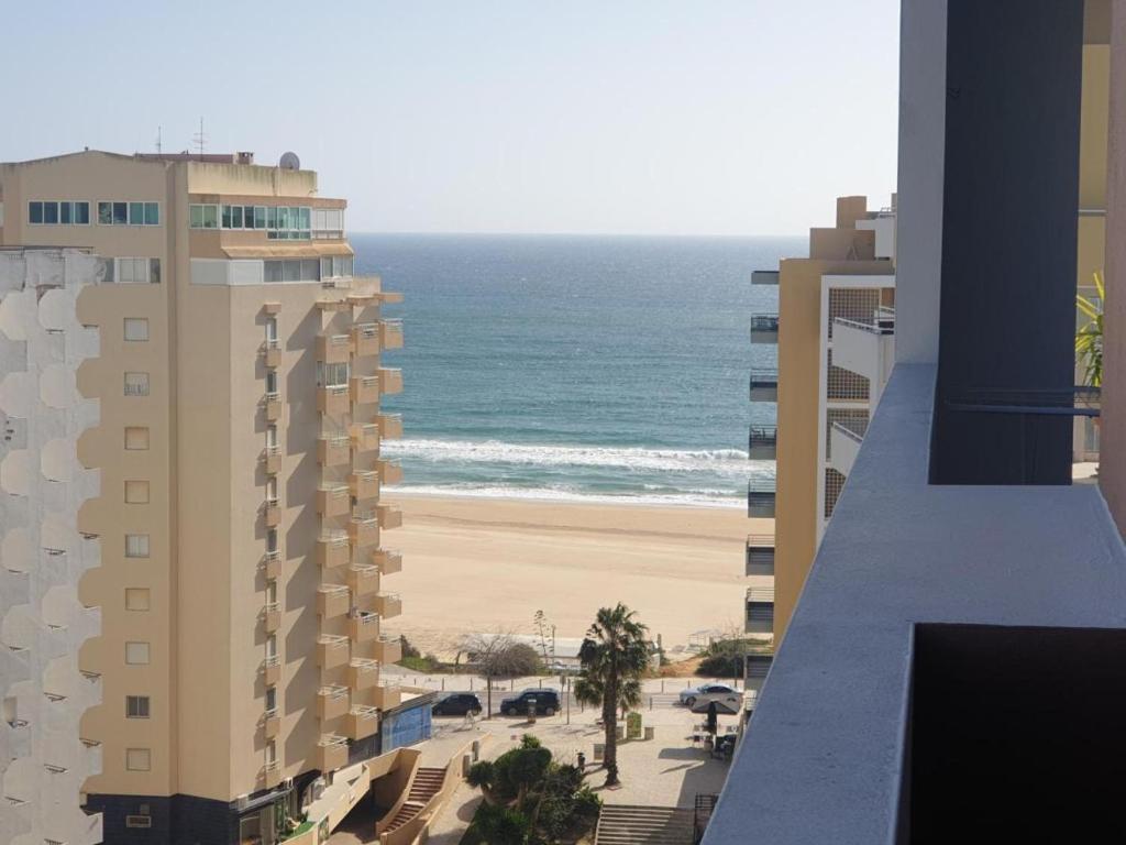 a view of the beach from the balcony of a building at Elite Residense a 150 mts Praia da Rocha in Portimão