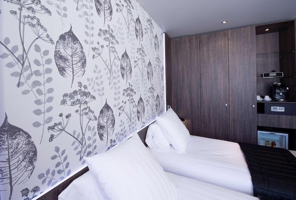 a bedroom with a bed with a floral wall at Best Western Premier Le Patio des Artistes Wellness Jacuzzi in Cannes