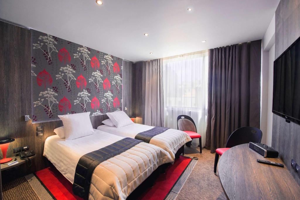 a hotel room with a bed and a table at Best Western Premier Le Patio des Artistes Wellness Jacuzzi in Cannes