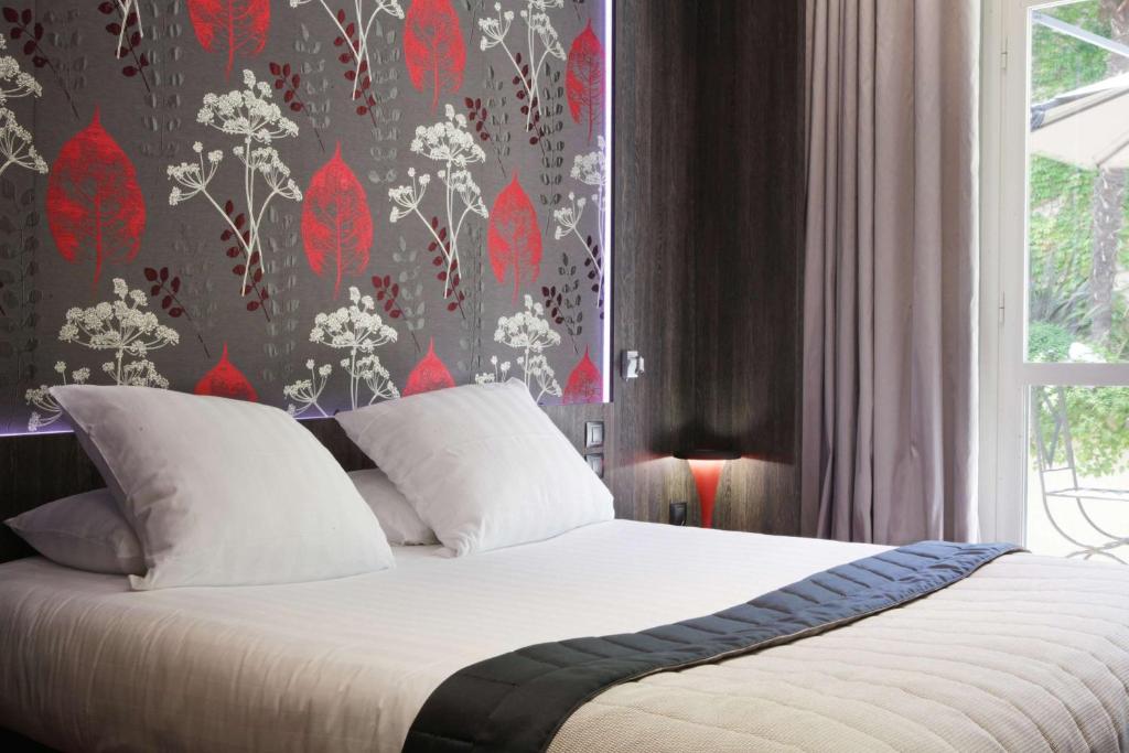 a bedroom with a bed with a red and white wallpaper at Best Western Premier Le Patio des Artistes Wellness Jacuzzi in Cannes