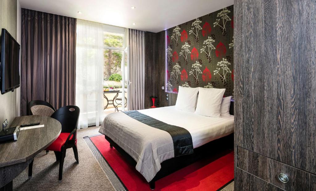 a hotel room with a bed and a desk at Best Western Premier Le Patio des Artistes Wellness Jacuzzi in Cannes