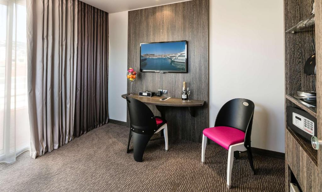 a hotel room with a table and two chairs at Best Western Premier Le Patio des Artistes Wellness Jacuzzi in Cannes