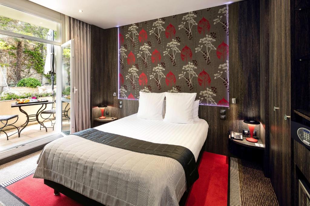a hotel room with a bed and a balcony at Best Western Premier Le Patio des Artistes Wellness Jacuzzi in Cannes