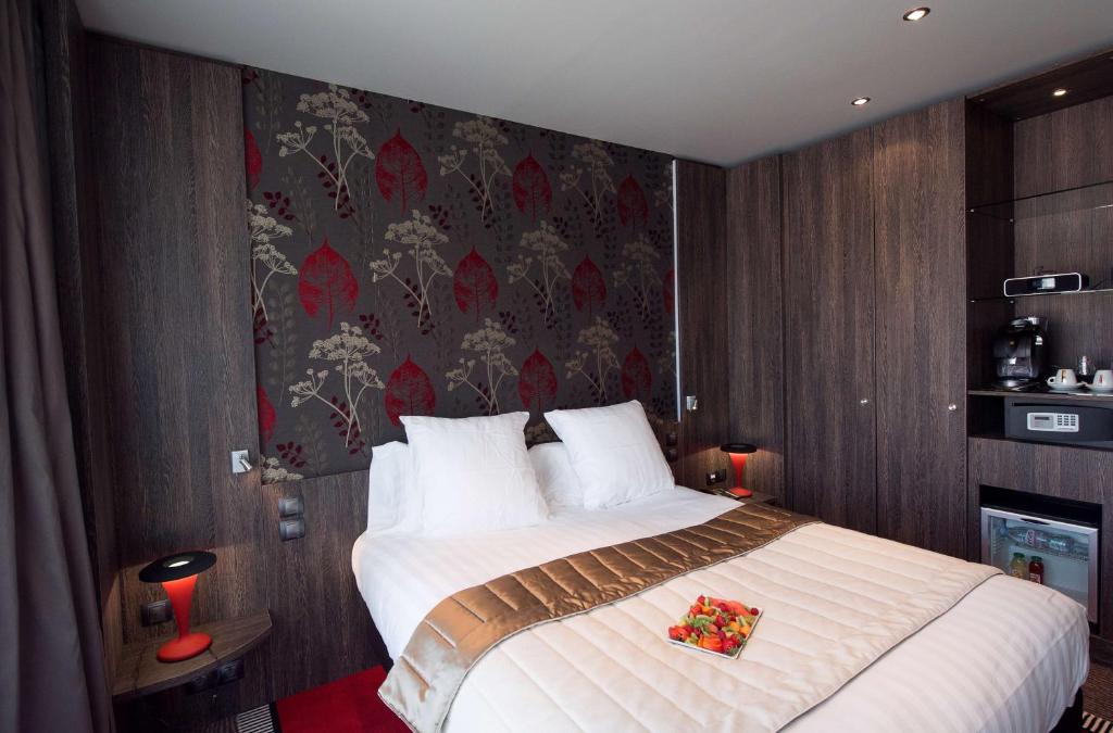 a bedroom with a large bed with flowers on it at Best Western Premier Le Patio des Artistes Wellness Jacuzzi in Cannes