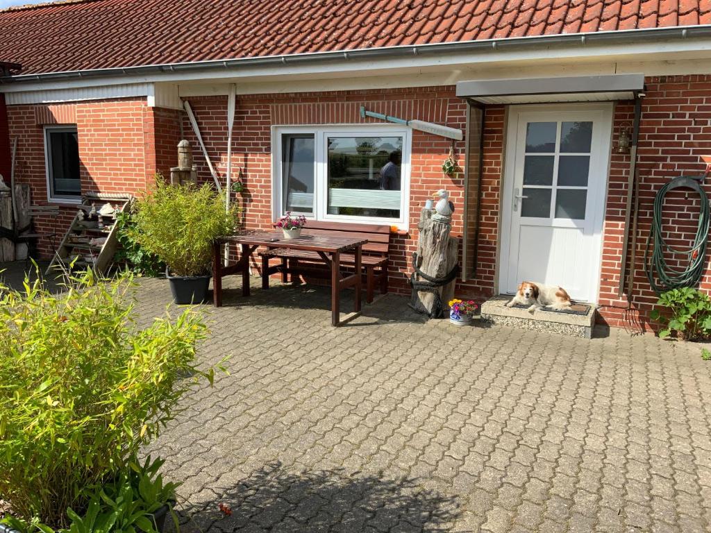 a dog laying next to a table in front of a house at Ankerplatz in Winnemark