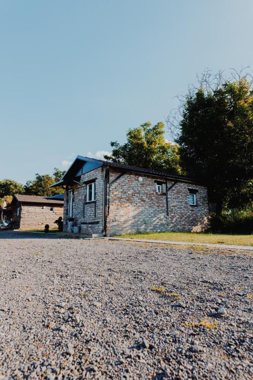 a brick house sitting on top of a gravel road at OPG Dokić in Kopačevo