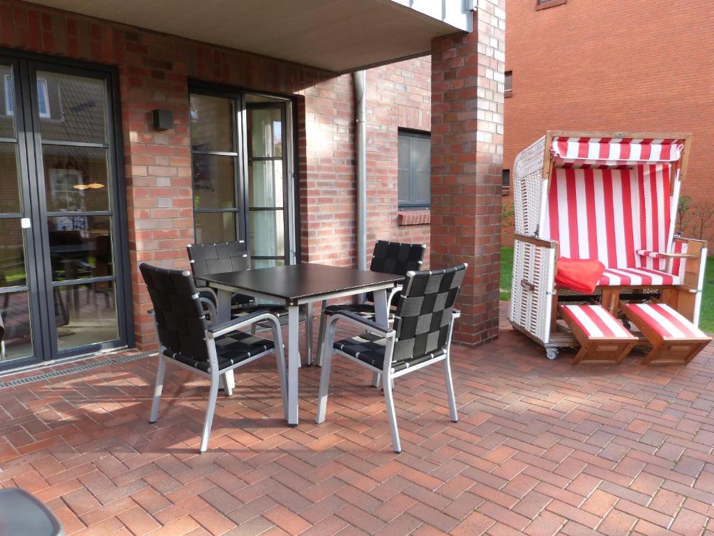 une table et des chaises assises sur une terrasse dans l'établissement Ferienwohnung Jung, à Sankt Peter-Ording