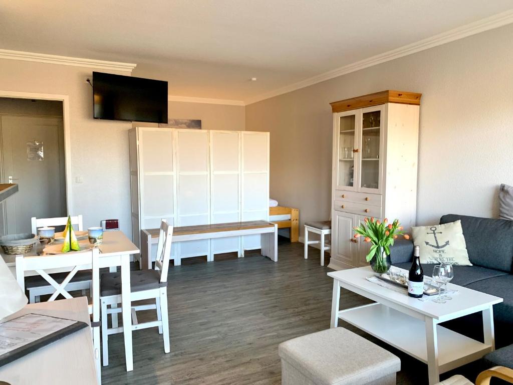 ein Wohnzimmer mit einem Sofa und einem Tisch in der Unterkunft Apartment "Achtern Diek" im Haus Atlantic in Sankt Peter-Ording