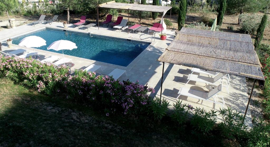 una vista sul soffitto di una piscina con sedie e ombrelloni di clair de lune a Saint-Rémy-de-Provence