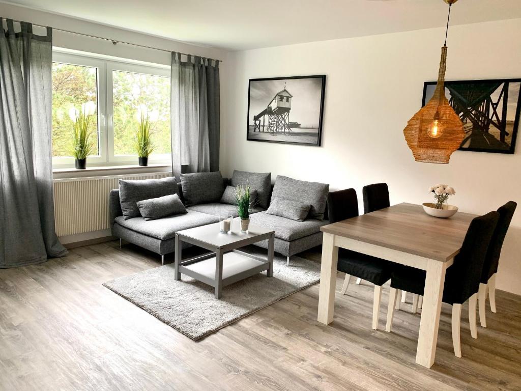 ein Wohnzimmer mit einem Sofa und einem Tisch in der Unterkunft Ferienwohnung "Fritz 17" in Sankt Peter-Ording