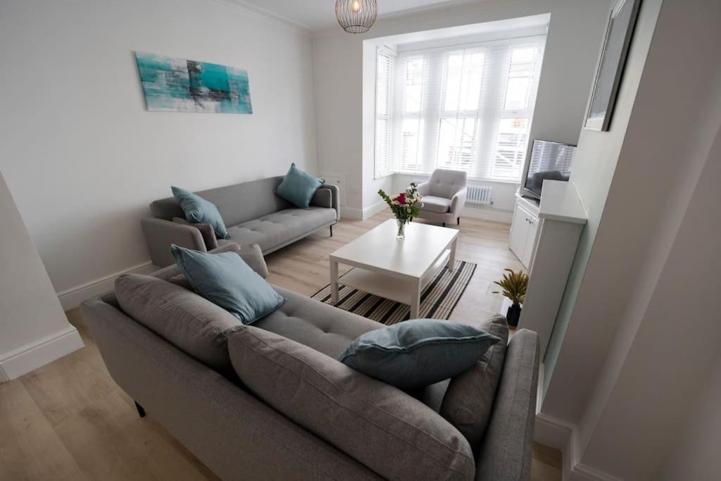 a living room with a couch and a table at Spacious Holiday Home in Porthcawl in Porthcawl