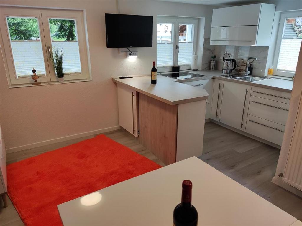 a kitchen with white cabinets and a red rug at Allgäuerferienwohnung in Sulzberg