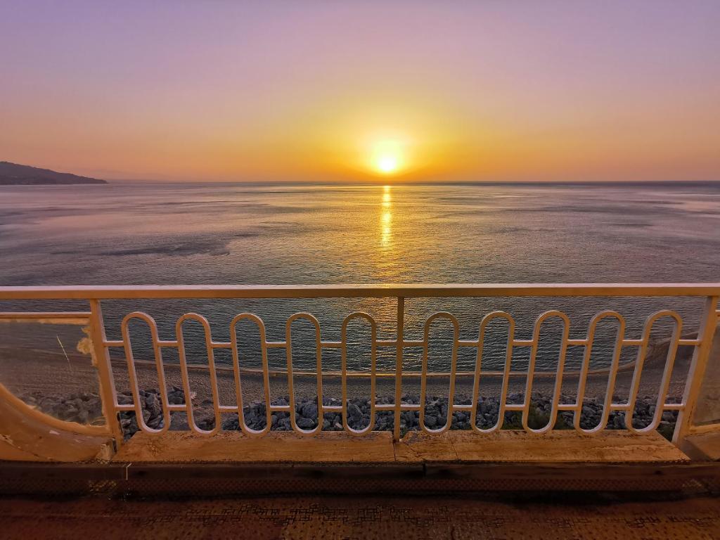 um banco na praia a ver o pôr-do-sol em Palazzo Nistico' em Soverato Marina