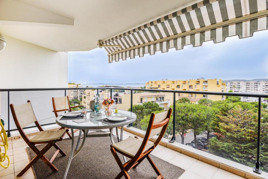 a balcony with a table and chairs and a view at Le Lido in Cagnes-sur-Mer