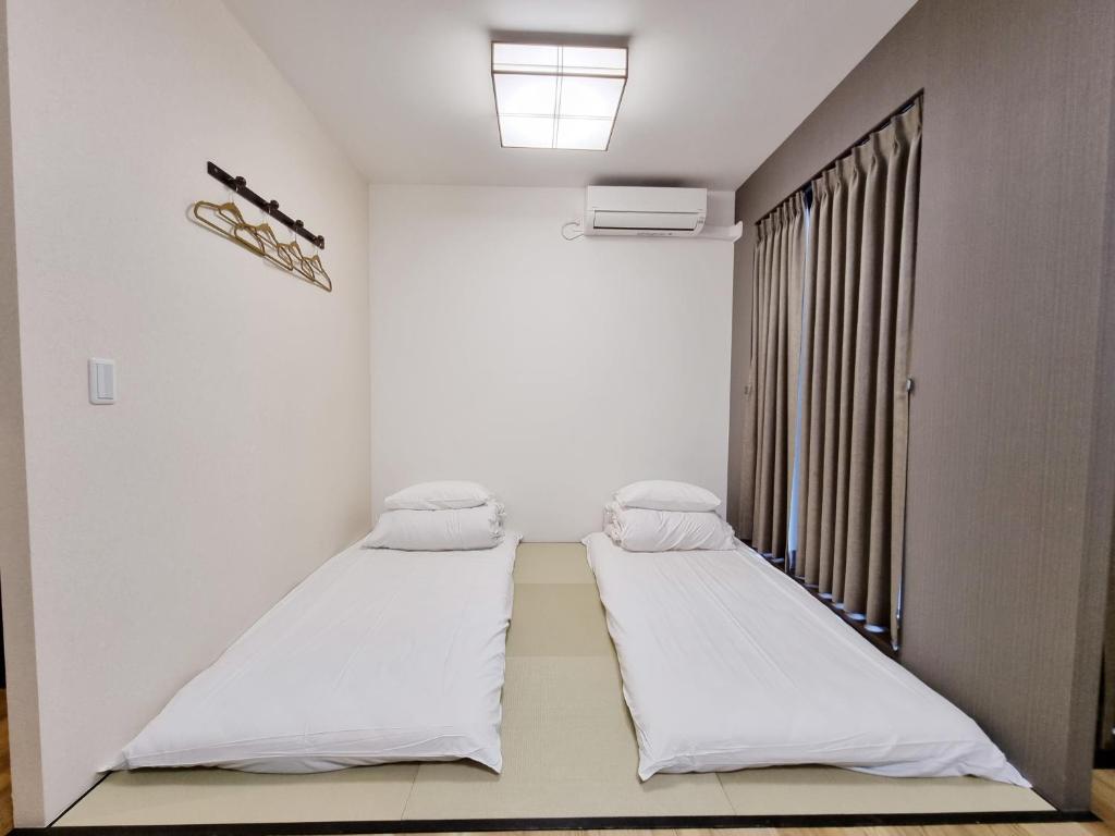Posteľ alebo postele v izbe v ubytovaní KYU KYU HOTEL