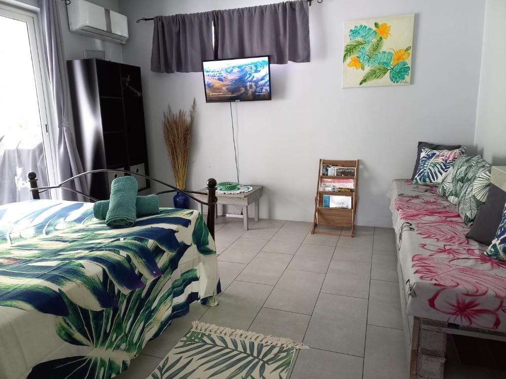 - une chambre avec 2 lits et un canapé dans l'établissement Rava Lodge, à Punaauia