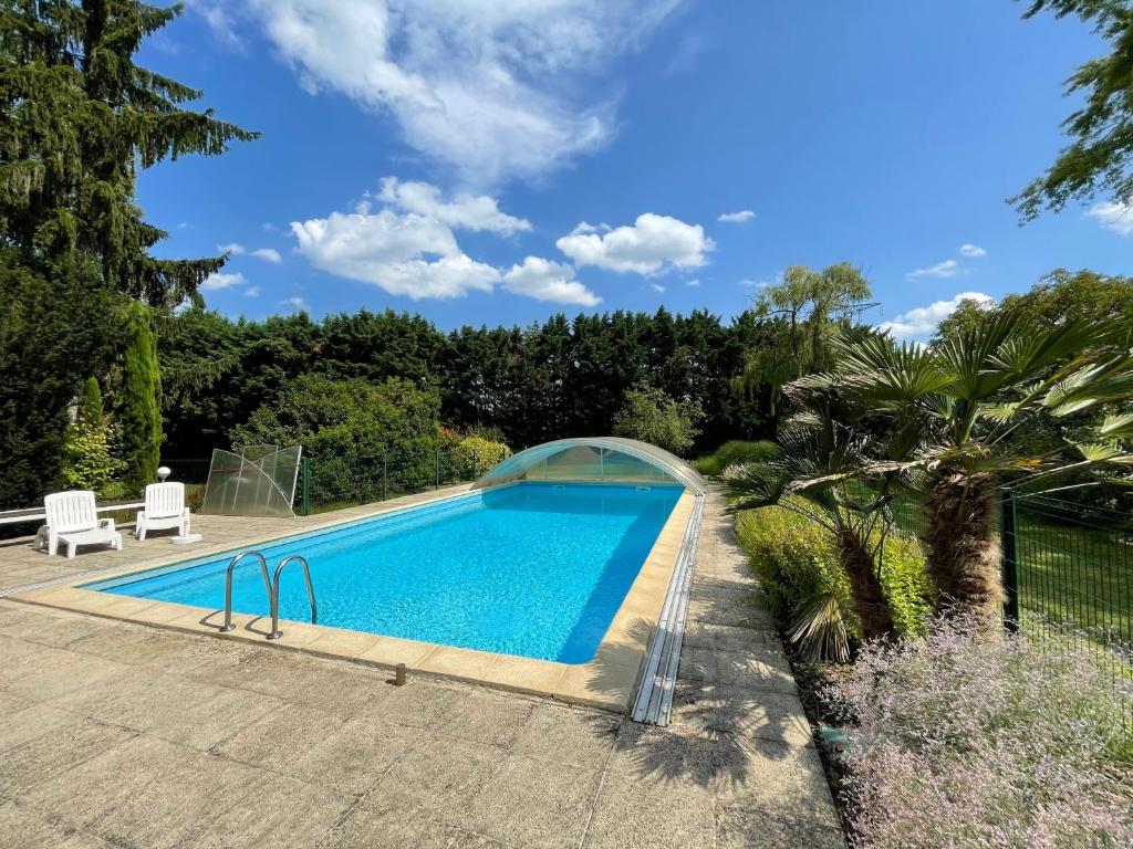 a swimming pool in a garden with a bridge over it at Rose - piscine partagée - proche Europa Park in Hessenheim