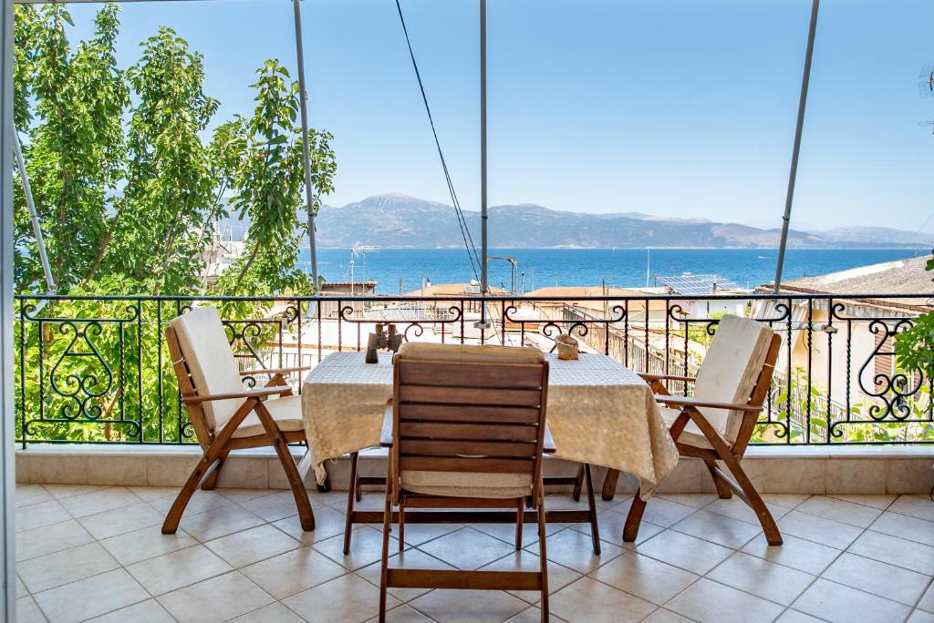 una mesa y sillas en un balcón con vistas al océano en Σελιανίτικα, διαμέρισμα με θέα -50μ από τη θάλασσα, en Selianitika