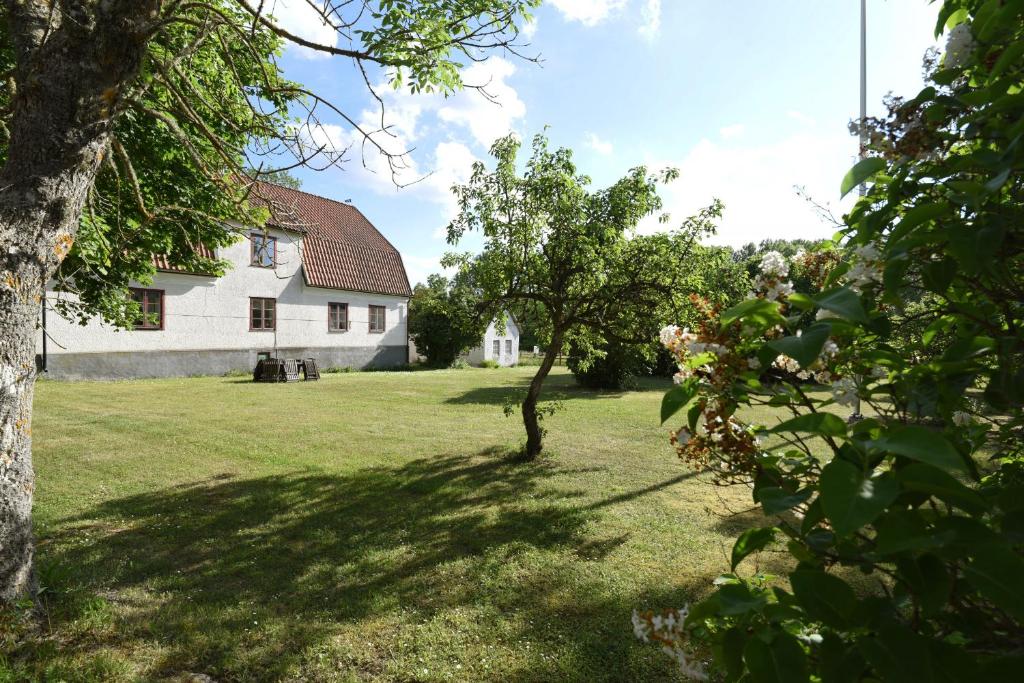 una casa blanca con un árbol en el patio en Cozy holiday home located on Gotland en Slite