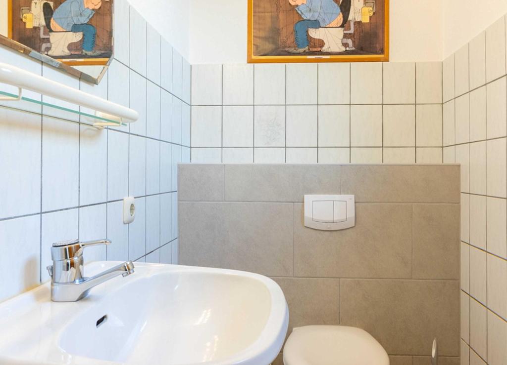 La salle de bains est pourvue d'un lavabo et de toilettes. dans l'établissement Haus Suedwind, à Hooksiel