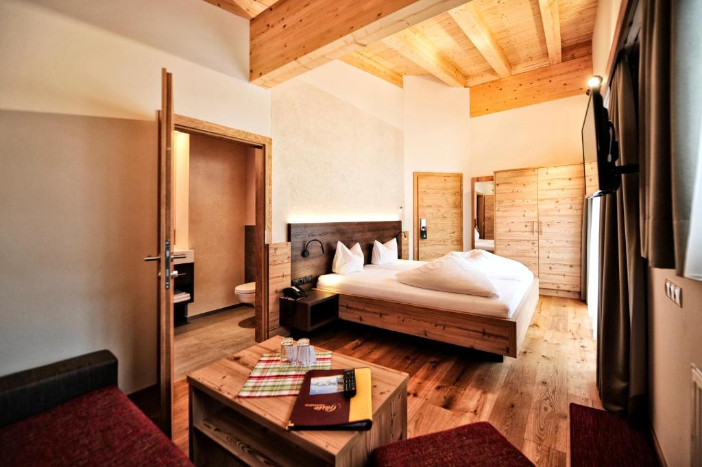 ein Hotelzimmer mit einem Bett und einem Tisch in der Unterkunft Hotel Garni Lamm in Nauders