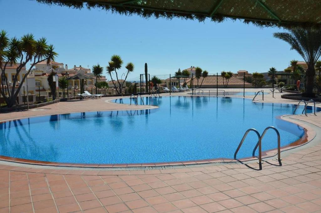 a large swimming pool in a resort with palm trees at Fuerteventura Relax and Sea in Antigua