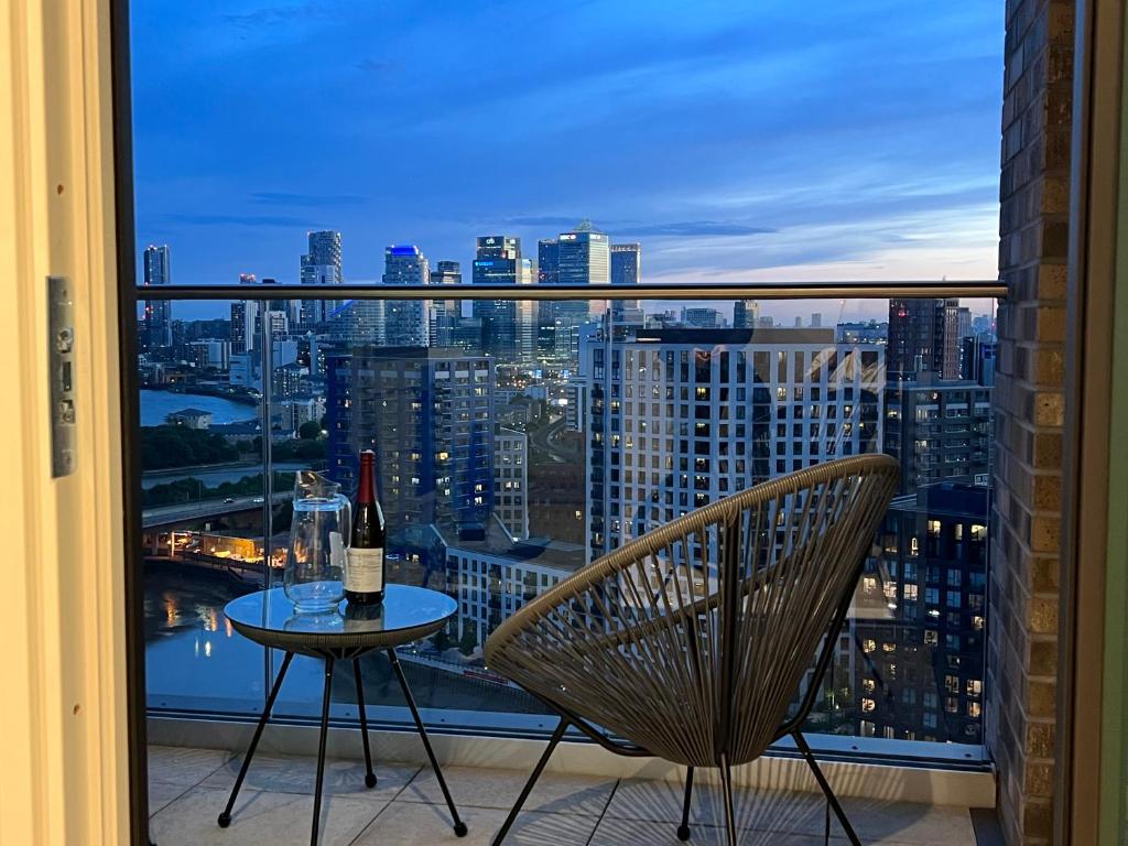 a bottle of wine sitting on a table on a balcony at Luxury penthouse with stunning views near Canary Wharf in London