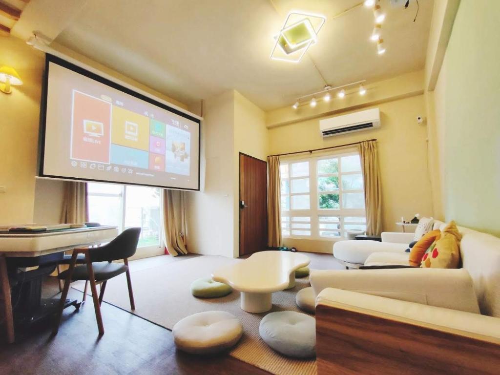 a living room with a flat screen tv and a couch at 冬映Winn 愛毛孩包棟民宿l寵物友善l不限時歡唱KTV in Wujie