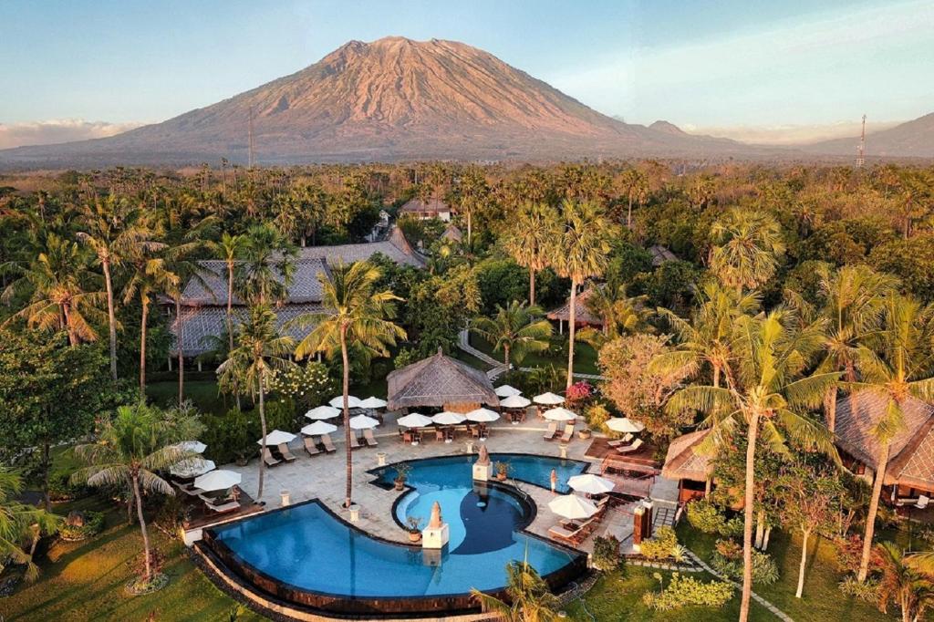 an aerial view of a resort with a mountain in the background at Siddhartha Oceanfront Resort & Spa Bali in Tulamben