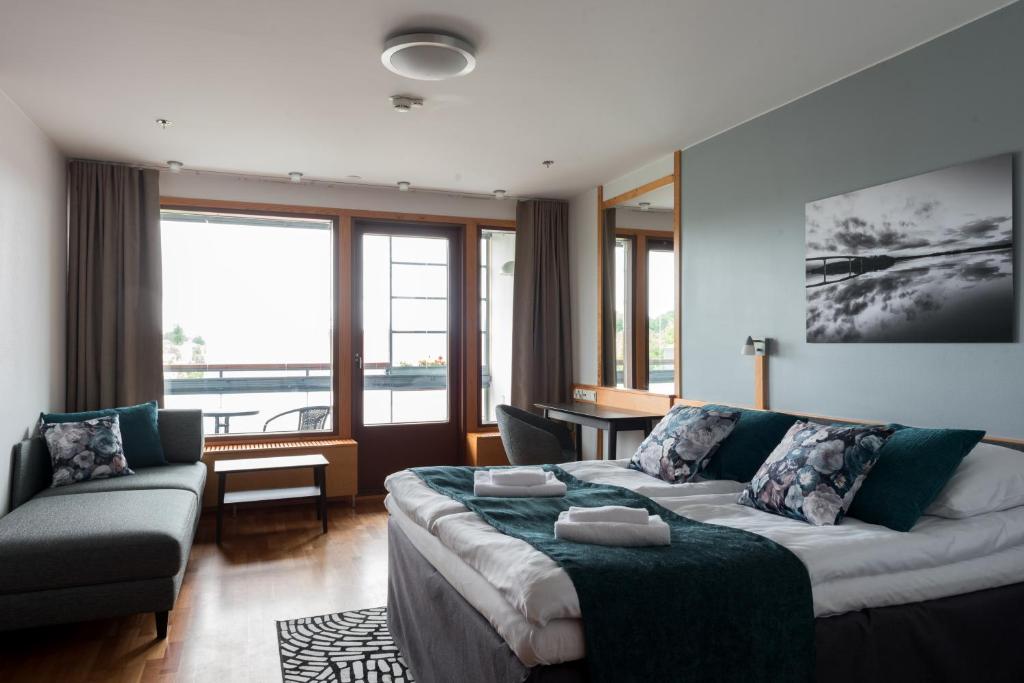 ein Wohnzimmer mit einem Sofa und einem großen Fenster in der Unterkunft Hotelli Lähde in Lappeenranta