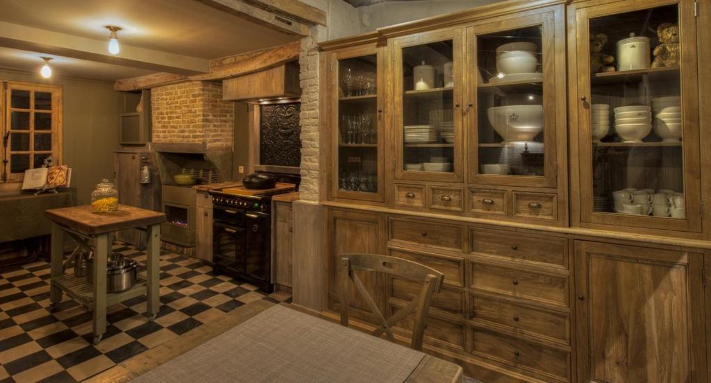 eine Küche mit Holzschränken und einem karierten Boden in der Unterkunft De Reiskoffer in Oostvleteren