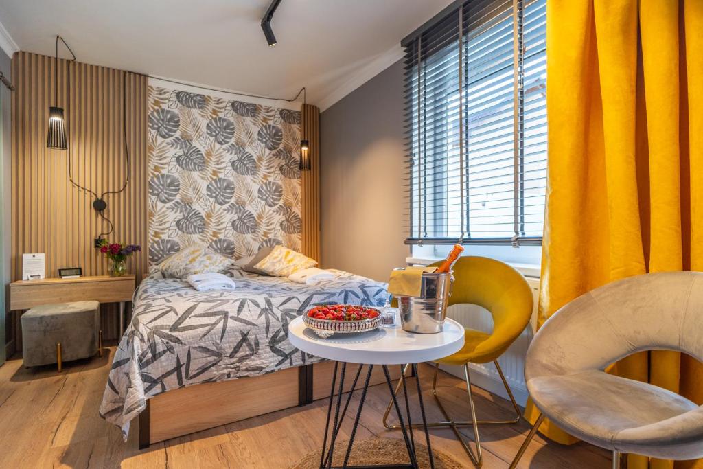 - une chambre avec un lit, une table et des chaises dans l'établissement Apartamenty Admirał , à Solina