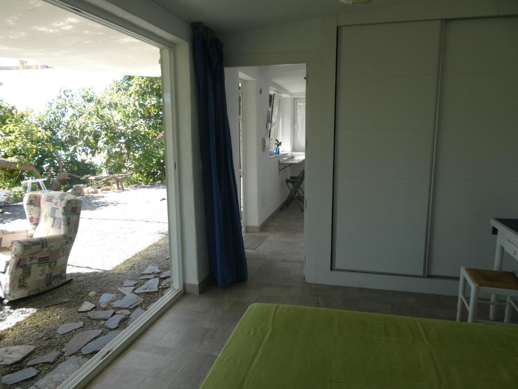 Cette chambre dispose d'une porte coulissante en verre donnant sur une cour. dans l'établissement Apartmento Pachamama, à Salobreña