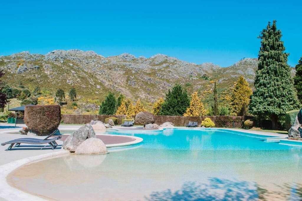 une piscine avec des chaises et des montagnes en arrière-plan dans l'établissement Just like Home - Number 8 em Quinta das Mineirinhas, à Vila Nova de Cerveira