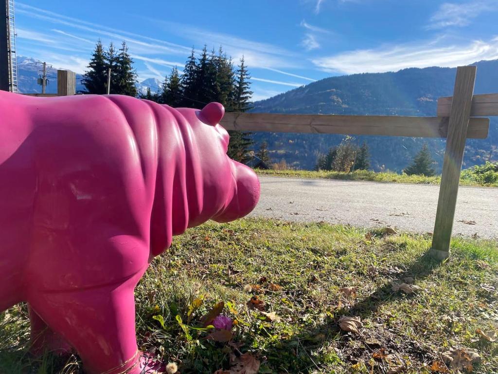 a pink elephant statue in the grass next to a fence at Chalet de 4 chambres avec jardin et wifi a La Lechere a 1 km des pistes in La Léchère