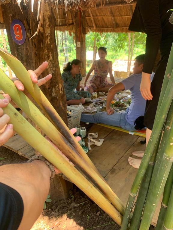 un groupe de personnes assises sous un arbre dans l'établissement Hoàng Ánh - Kon Xom Luh, à Kon Tum