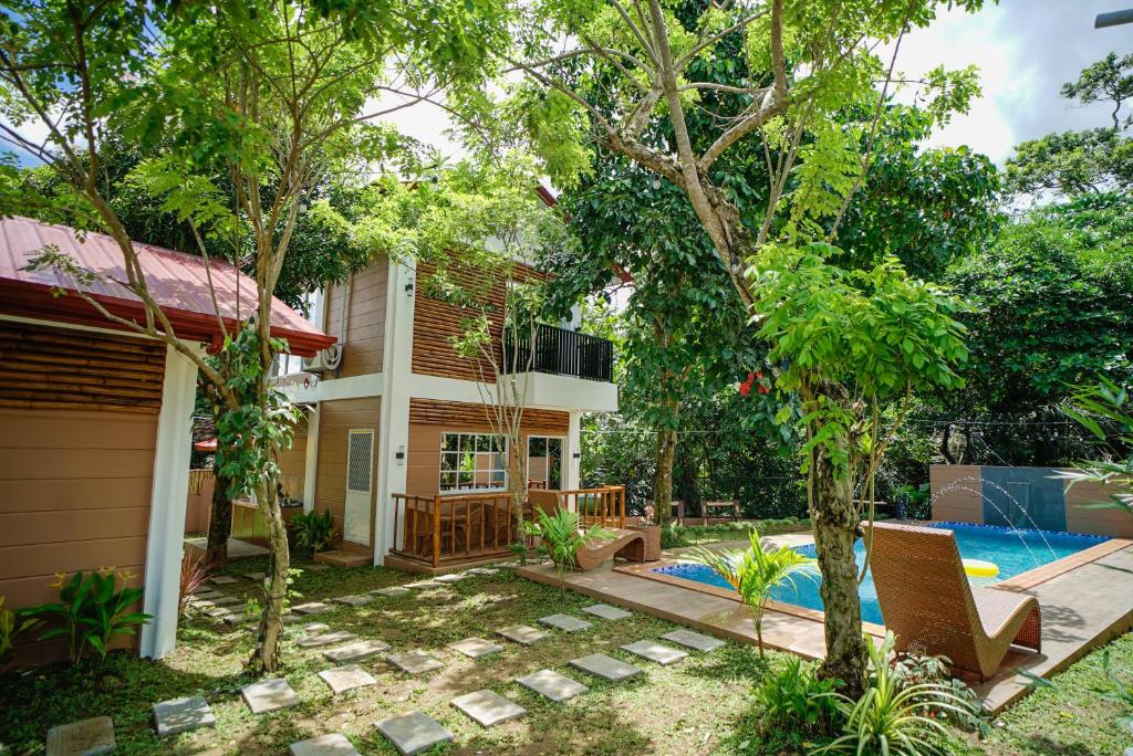 a backyard with a pool and a house at Balay Greenika Alfonso Nature Resort in Alfonso