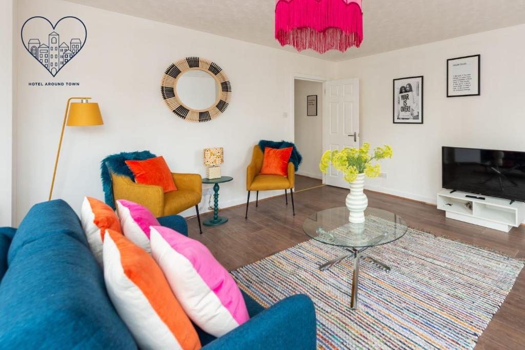 uma sala de estar com um sofá azul e cadeiras em Ground Floor 2 Bed Flat Slateford em Edinburgo