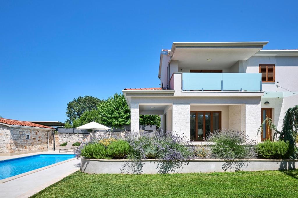 uma villa com uma piscina e uma casa em Vila Radini em Brtonigla