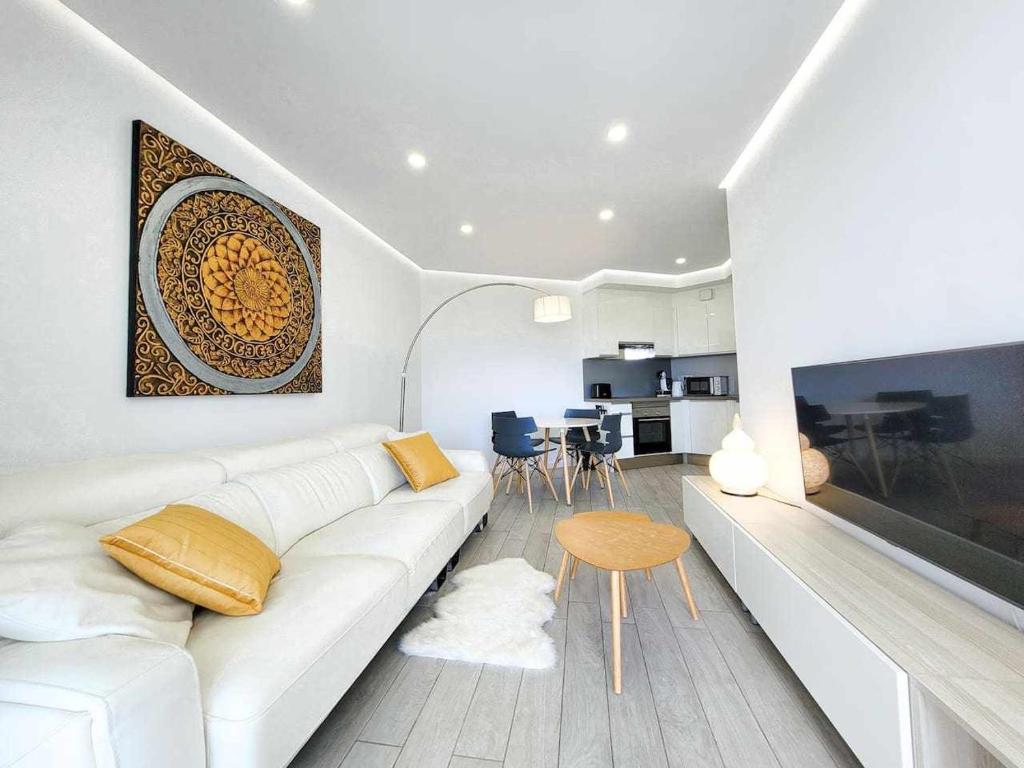 a white living room with a white couch and a table at Ocean Garden Suite El Sol in Adeje