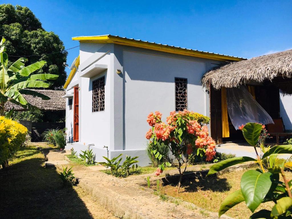 uma pequena casa branca com telhado de palha em Villa CHRIS, Calme et Sérénité em Andilana