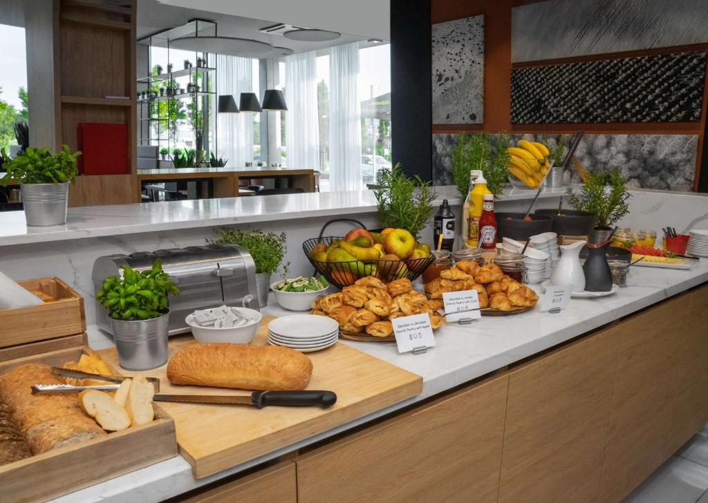 a buffet with bread and other food on a counter at Park Inn by Radisson Vilnius Airport Hotel & Conference Centre in Vilnius