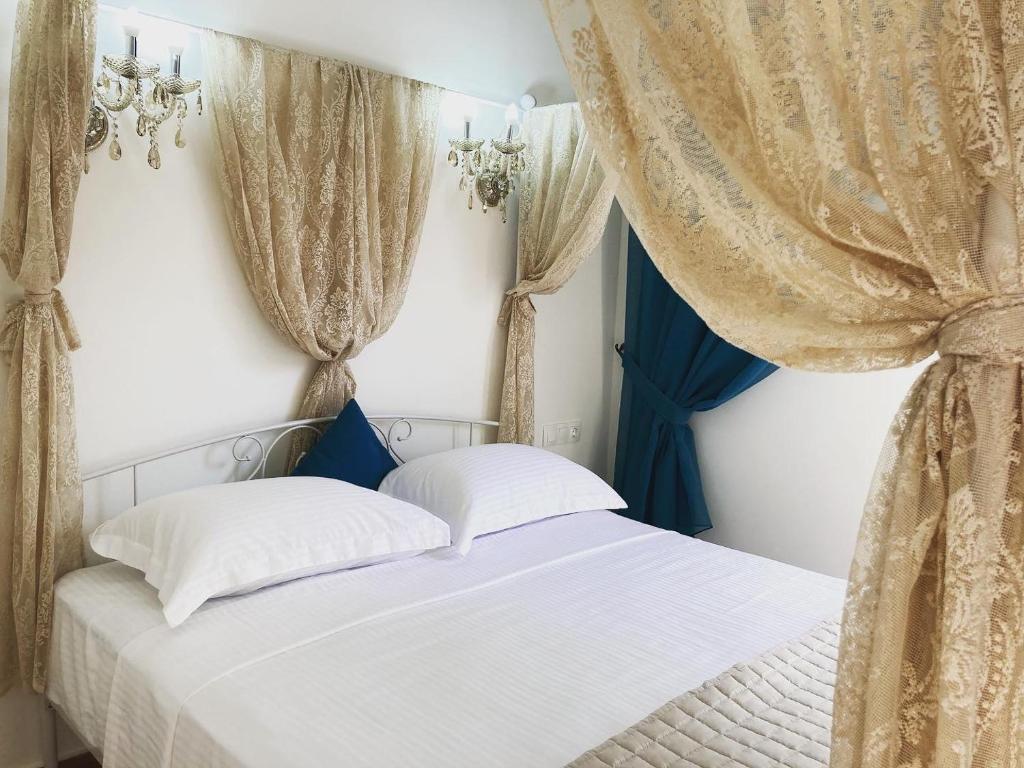 a bedroom with two beds and curtains at Villa Ulyana Sarti - Ancient Greece in Center in Sarti