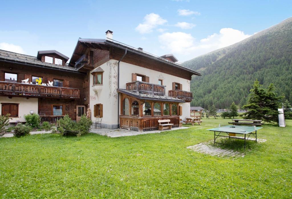 duży budynek ze stołem do ping ponga na dziedzińcu w obiekcie Appartamento Larice Chalet Cambra w Livigno