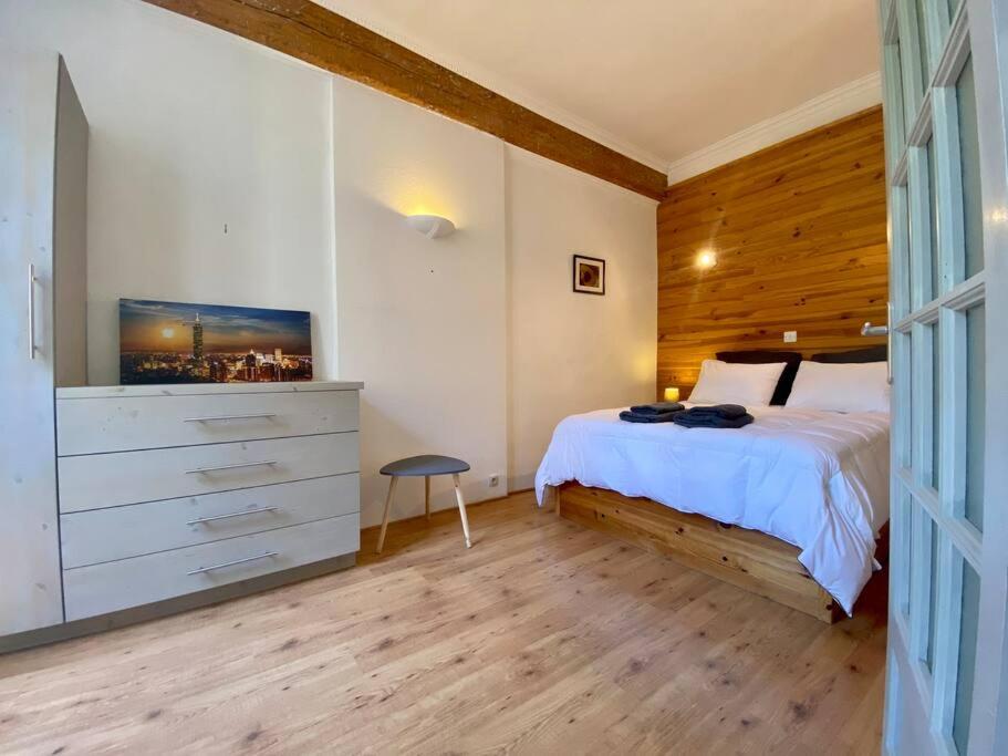a bedroom with a bed and a dresser in it at L'Armagnac in Carcassonne