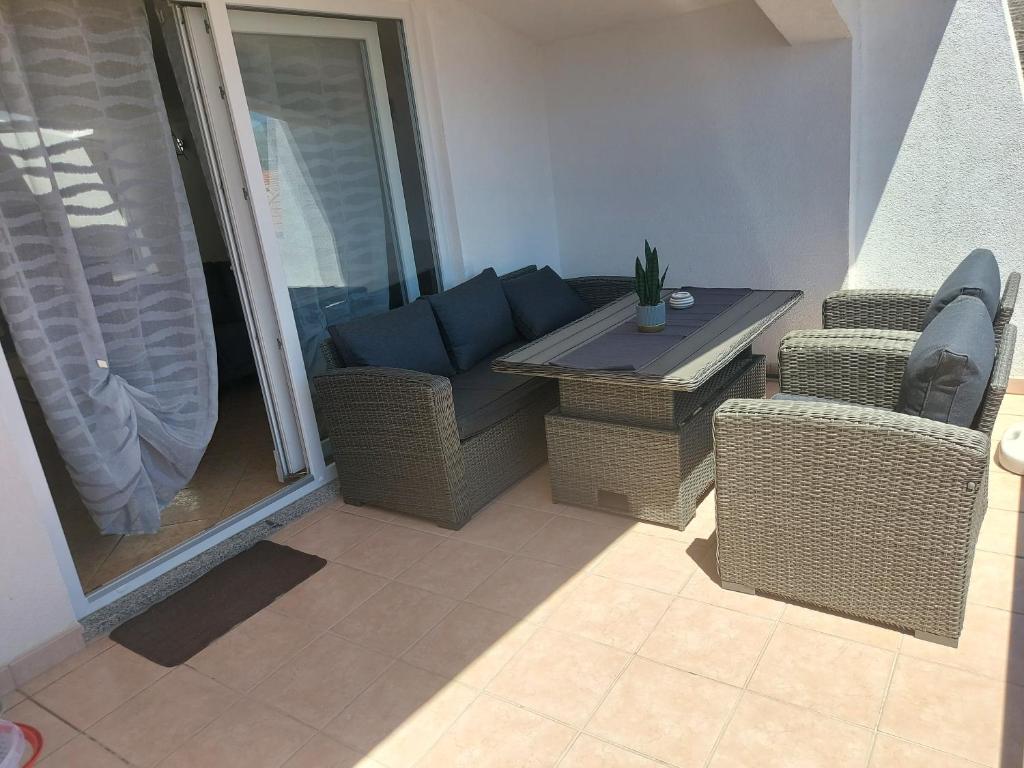 a balcony with a couch and a table and chairs at Apartments Prgin in Primošten