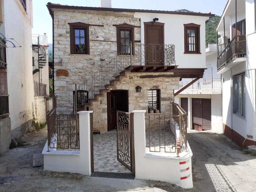 a stone house with a staircase in a street at Mama's Home, Kallirachi Village in Kallirakhi